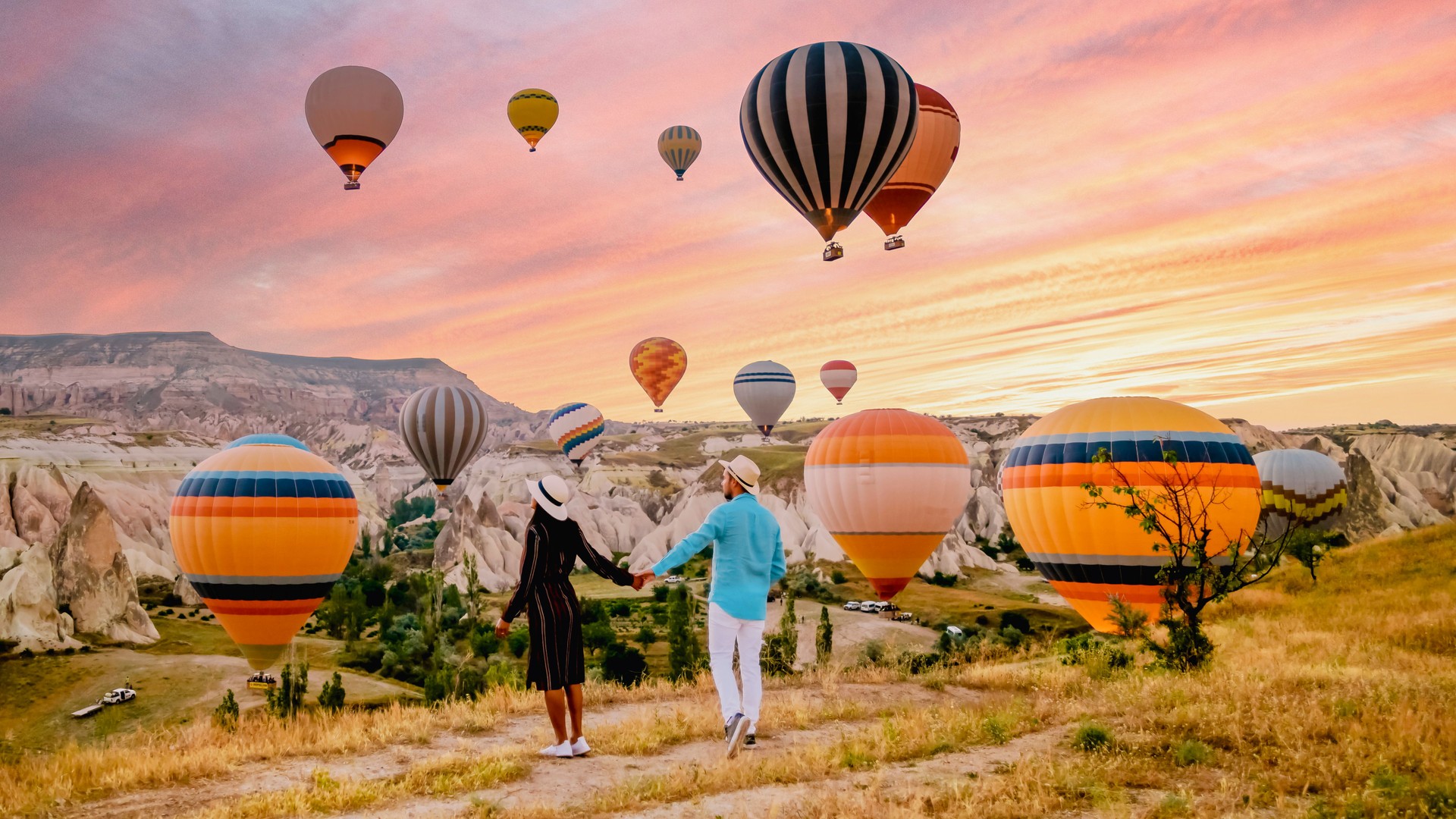 Kappadokien Türkei während Sonnenaufgang, Paar mittleren Alters Männer und Frauen im Urlaub in den Hügeln von Goreme Capadocia Türkei, Männer und Frauen suchen Sonne rsise mit Heißluftballons in Kappadokien