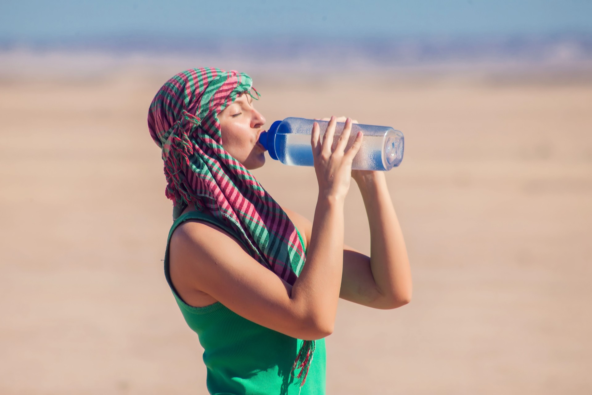 Woman drinks water in the desert of Egypt. Hot weather concept